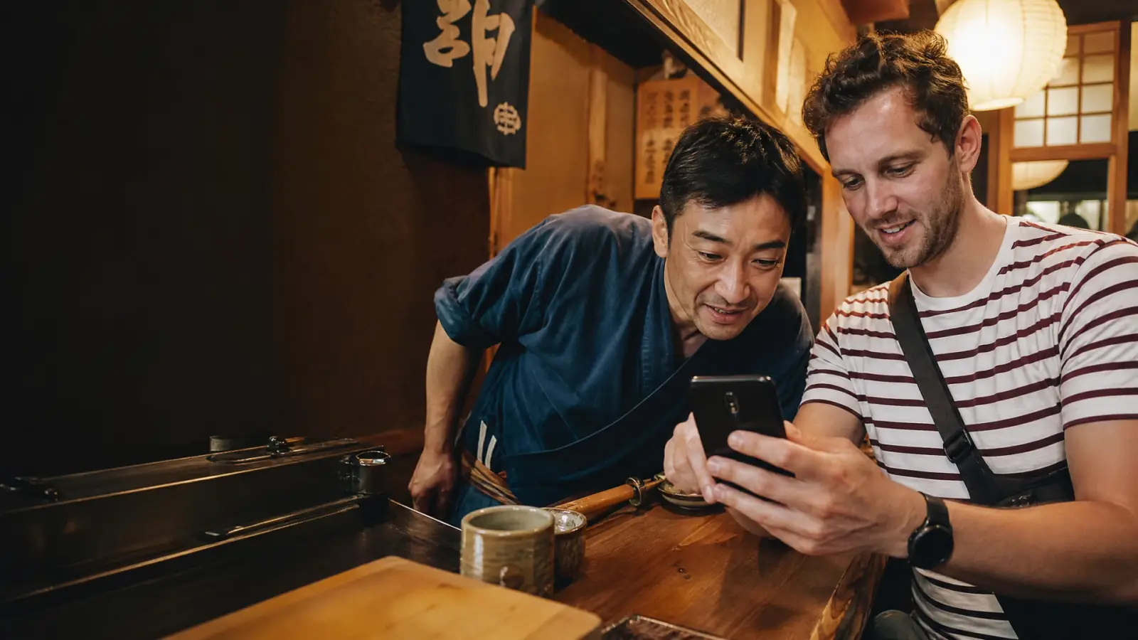 Western traveler and Japanese server looking together at the order on the phone
